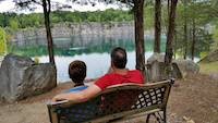 A Father and Son enjoy quality time while overlooking the lake and cliffs at the Coffey Grounds