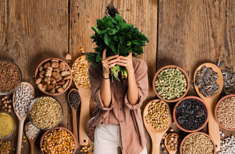 plant-based proteins and human holding greens in front of face