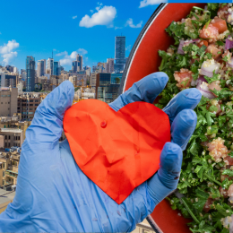 gloved hand holding paper heart, tabbouleh, and Beirut